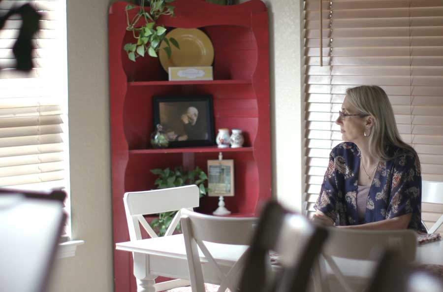 woman sitting at kitchen table alone